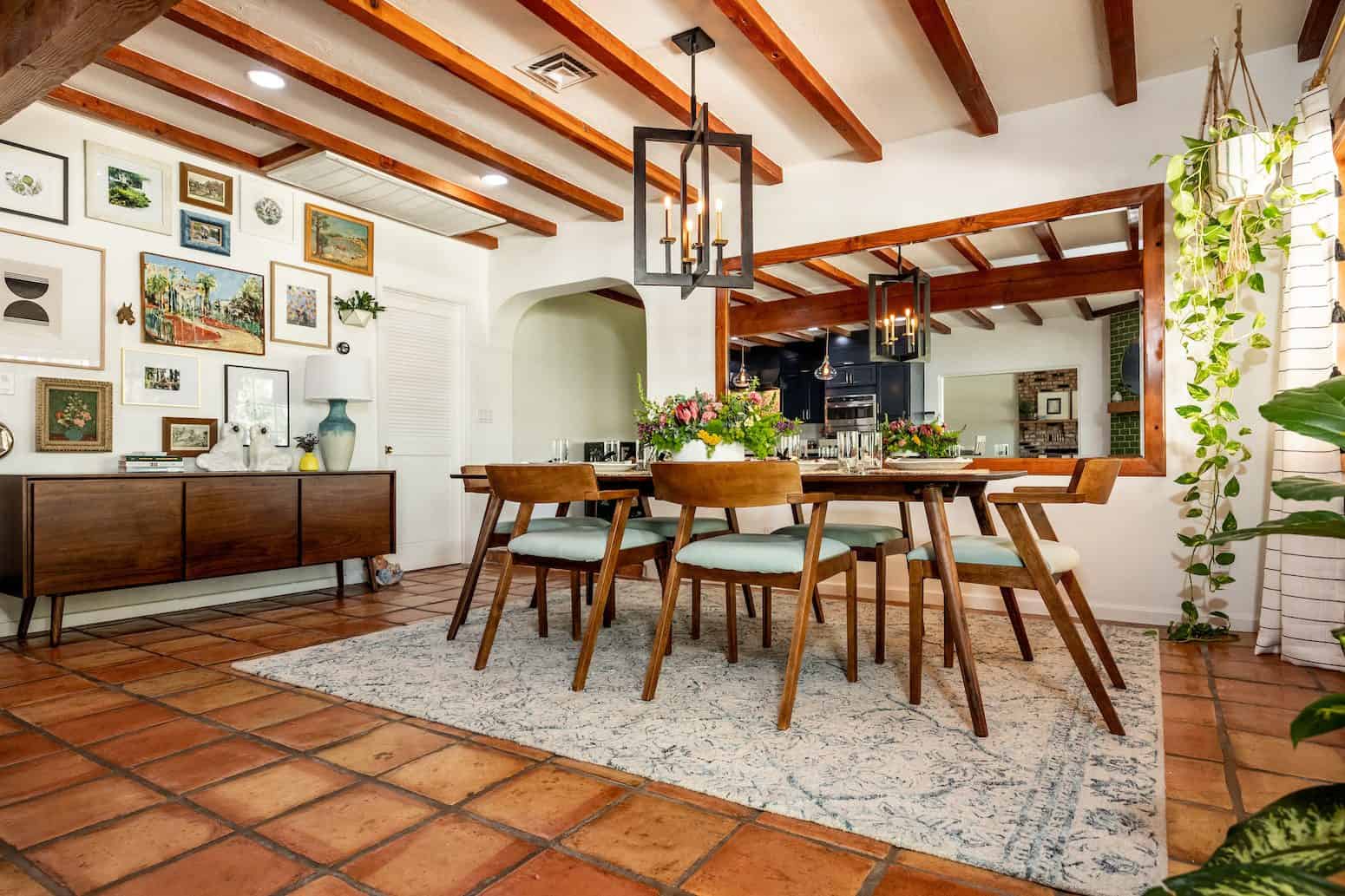 Dining room with wooden beams, gallery wall, and rustic furniture