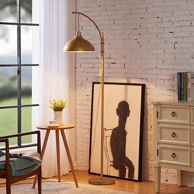 Cozy nook with gold floor lamp, chair, and abstract art.