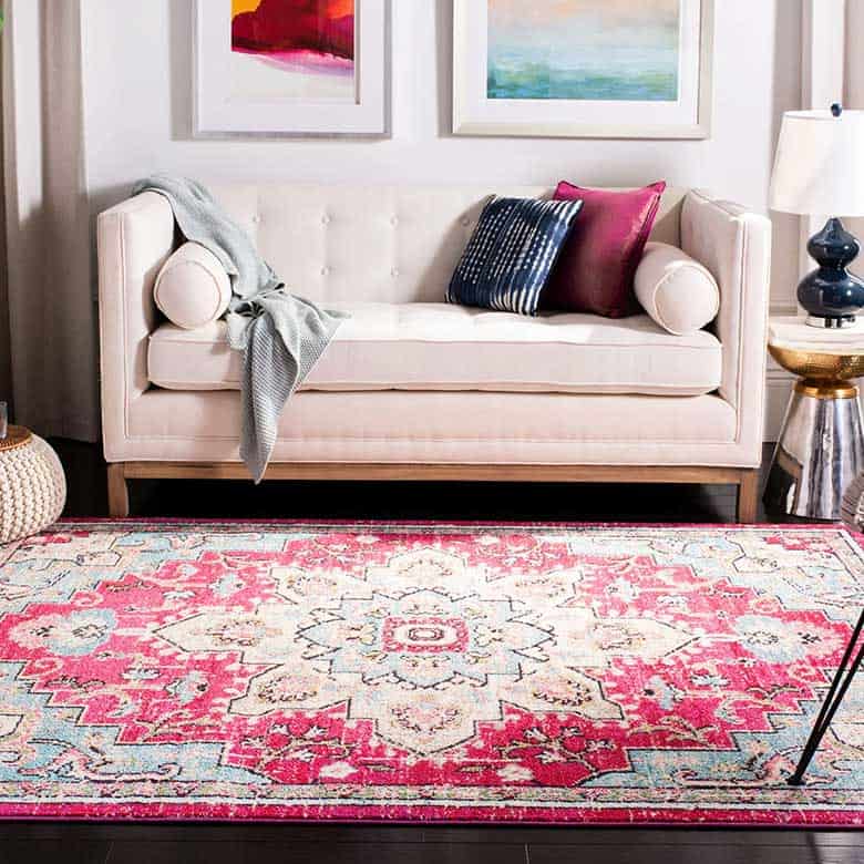 Stylish living room with cream sofa and vibrant pink patterned rug