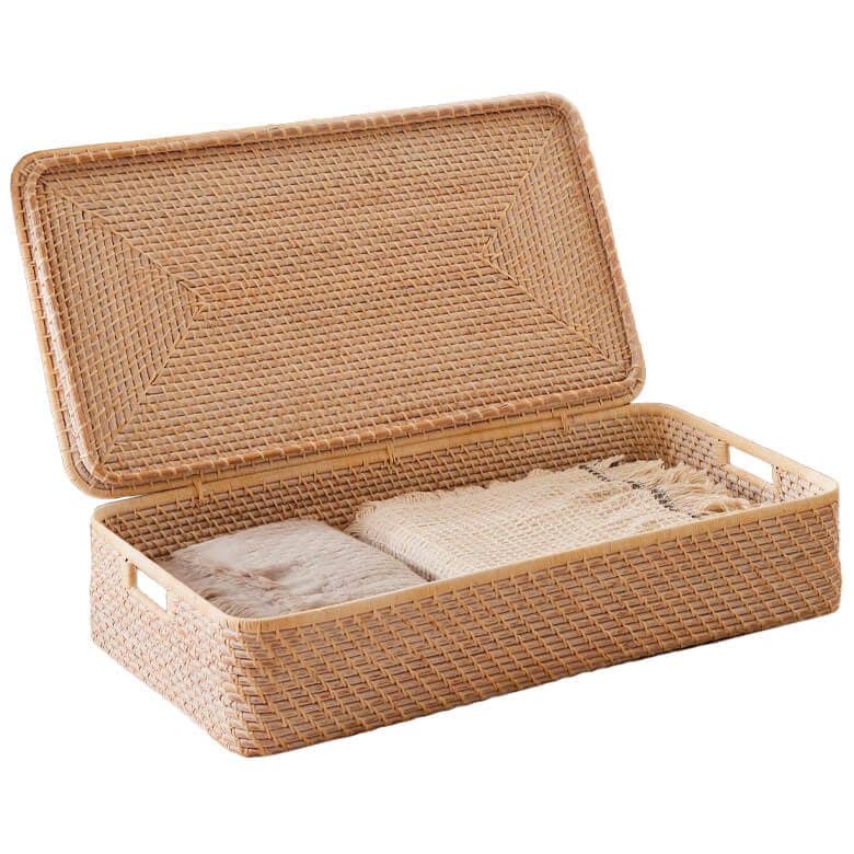 Woven rattan storage basket with lid, holding folded blankets