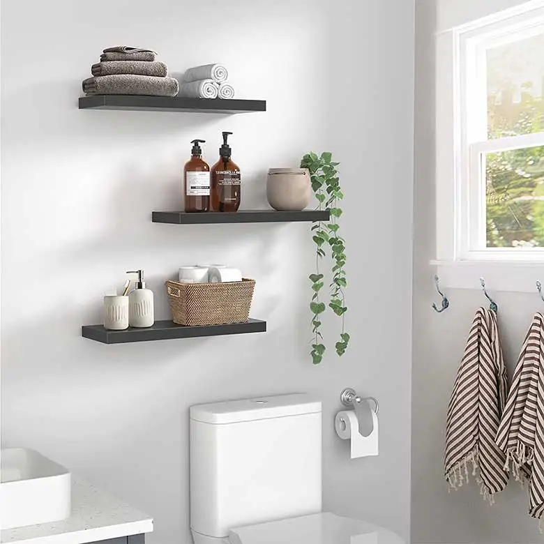Bathroom with toilet, black shelves, and striped towels
