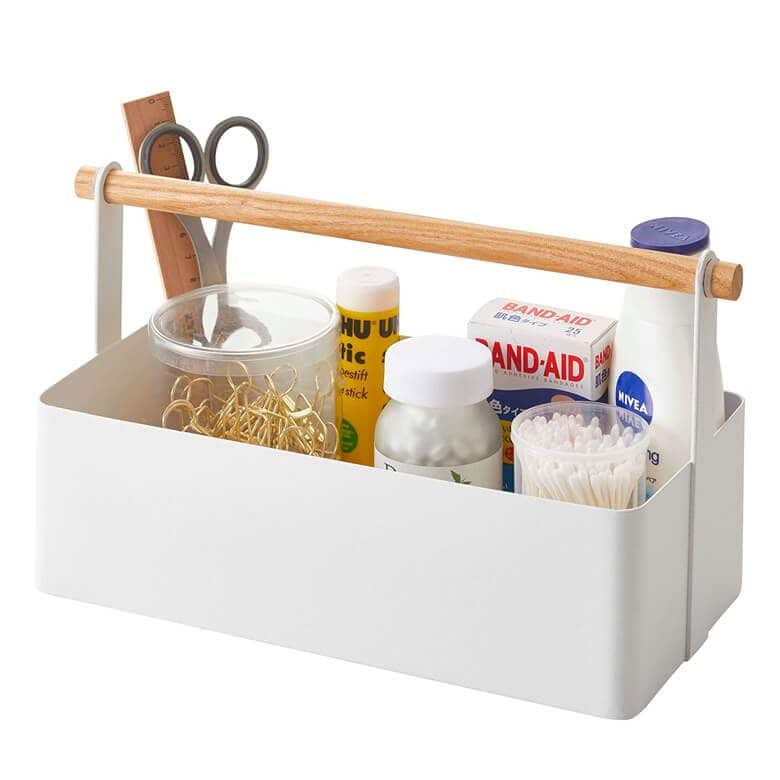 White storage caddy with wooden handle holding first aid supplies and office items