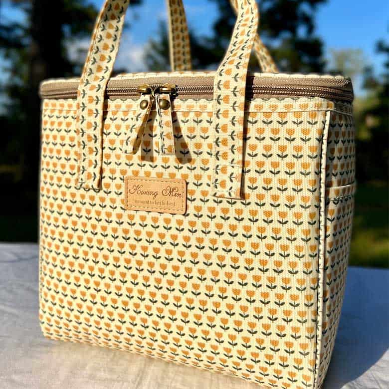 Patterned insulated tote bag with floral design and zipper closure