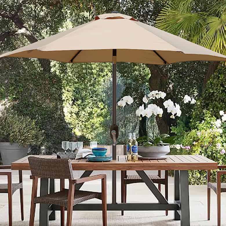 Stylish outdoor dining area with a large, beige patio umbrella
