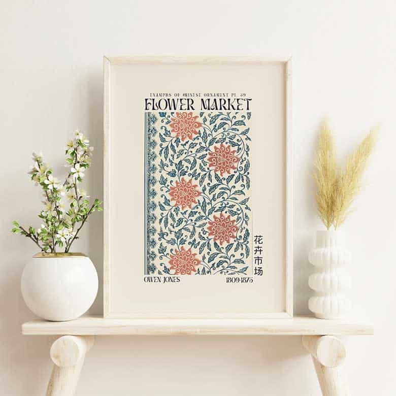 Framed floral art print on shelf with white ceramic vases