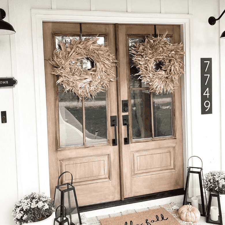 Fall front porch with double wood doors and dried wreaths