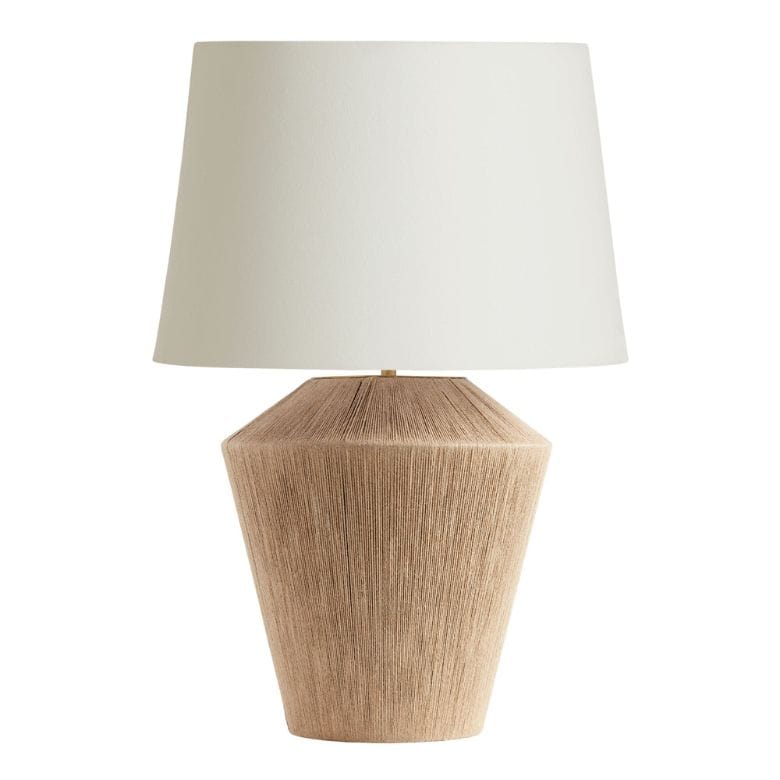 Table lamp with a textured tan base and a white fabric shade