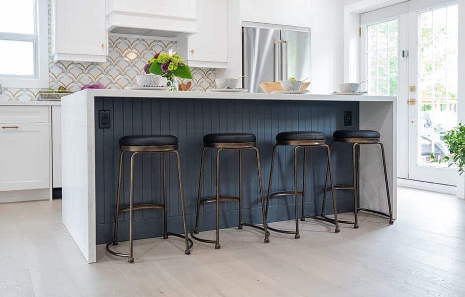 Kitchen island with bar stools and a stylish backsplash