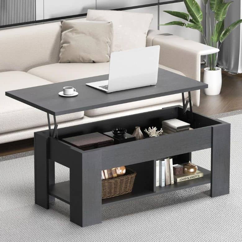 Modern black lift-top coffee table with hidden storage, placed in front of a beige sofa with a laptop and cup on top