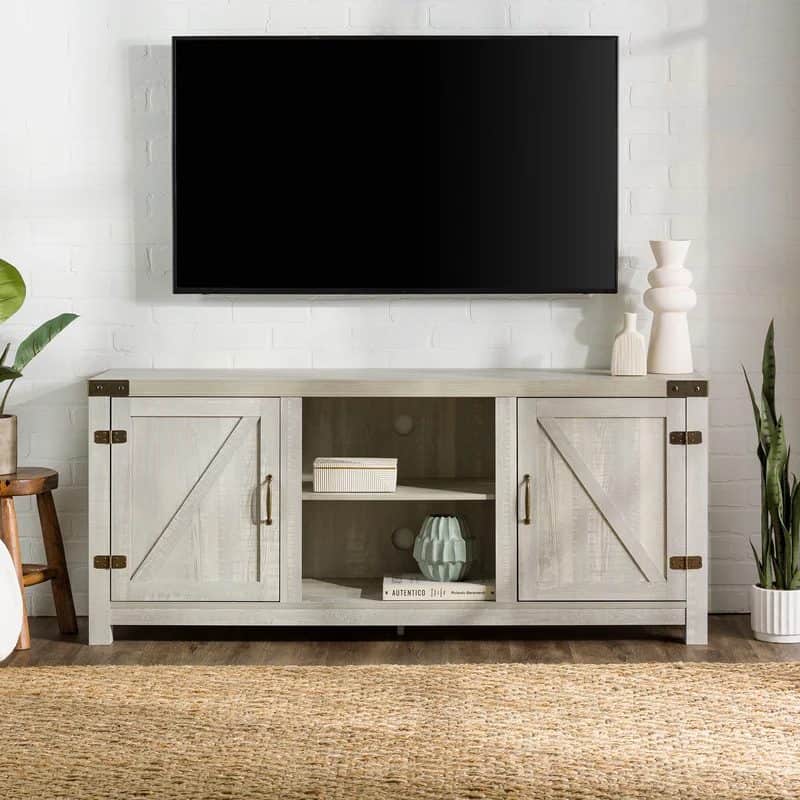 Farmhouse TV stand with barn doors, open shelf, metal accents, vases, and plants