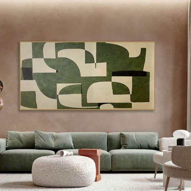 Living room with a green abstract painting above a green sofa and a round ottoman