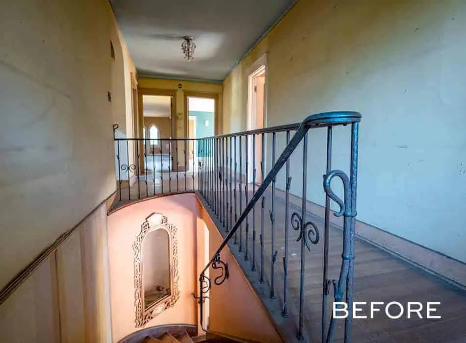 A before image of a hallway with a spiral staircase and metal railing