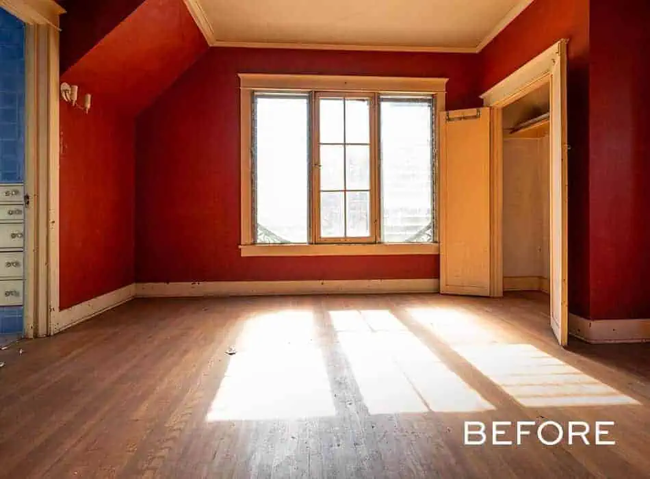 Before image of an empty bedroom with red walls, a large window, and hardwood floors