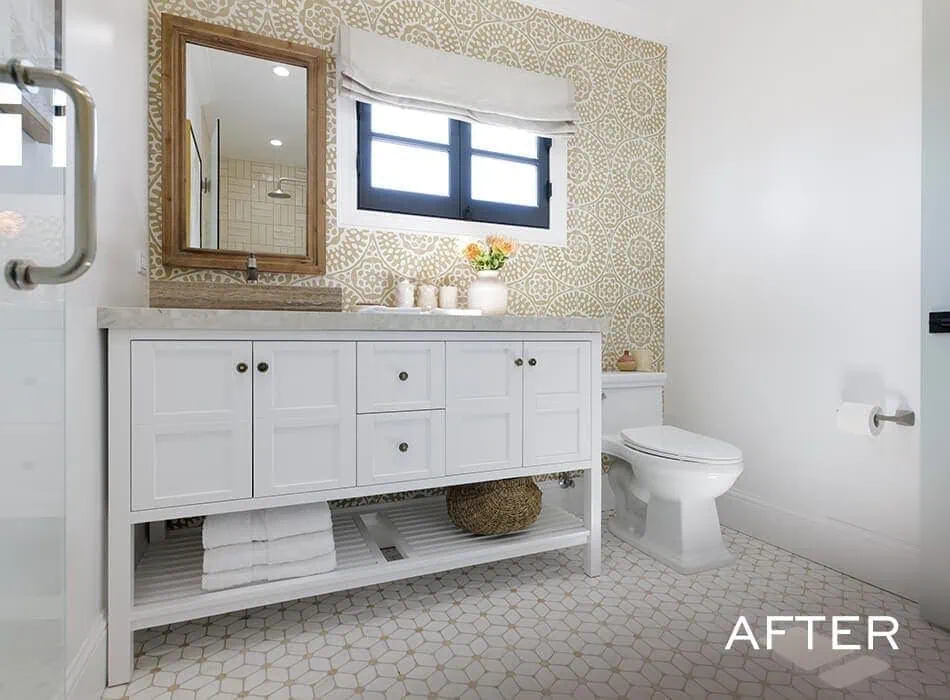 Renovated bathroom with patterned wallpaper, white vanity, and updated decor