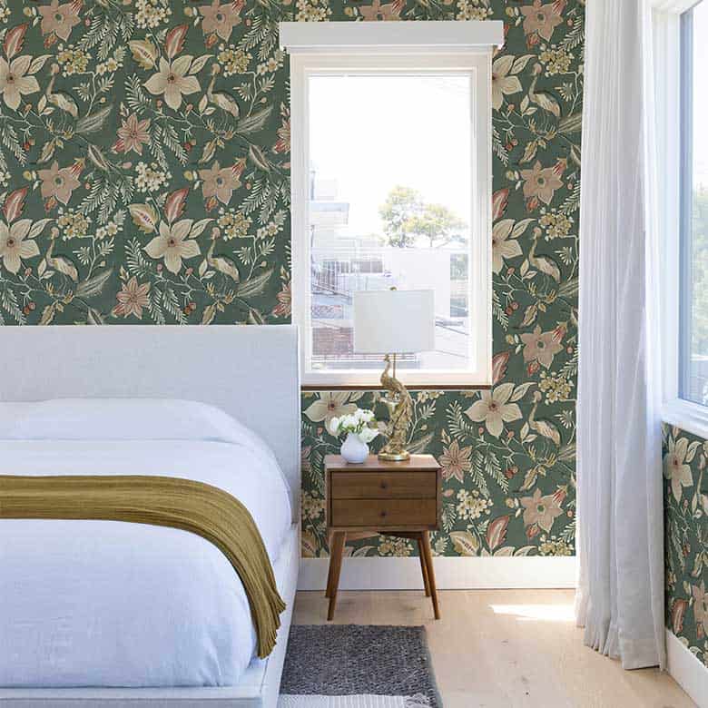 Bedroom with floral wallpaper, white bedding, and a wooden nightstand with a gold lamp