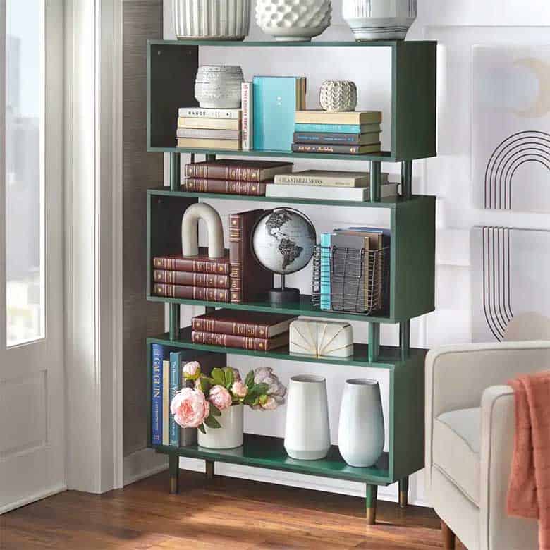Stylish bookshelf with books, decorative vases, a globe, and flowers, set in a modern living room corner