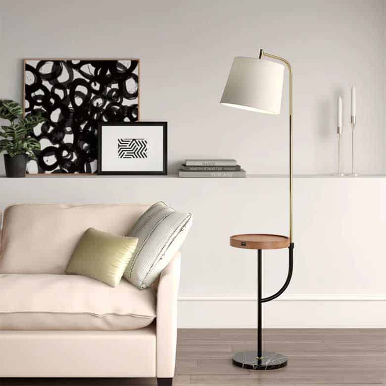 Living room with a beige sofa, floor lamp with a built-in table, and abstract artwork on the wall