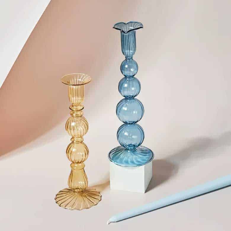 Yellow and blue ribbed glass candle holders with elegant sculptural designs