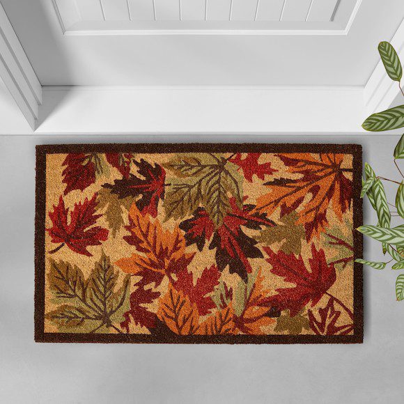 Autumn-themed doormat with colorful fall leaves at a front door entrance