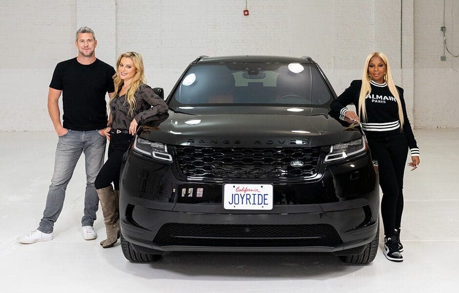 Three people with black Range Rover in studio