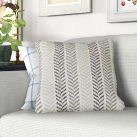 Decorative pillow with a herringbone pattern on a light gray couch