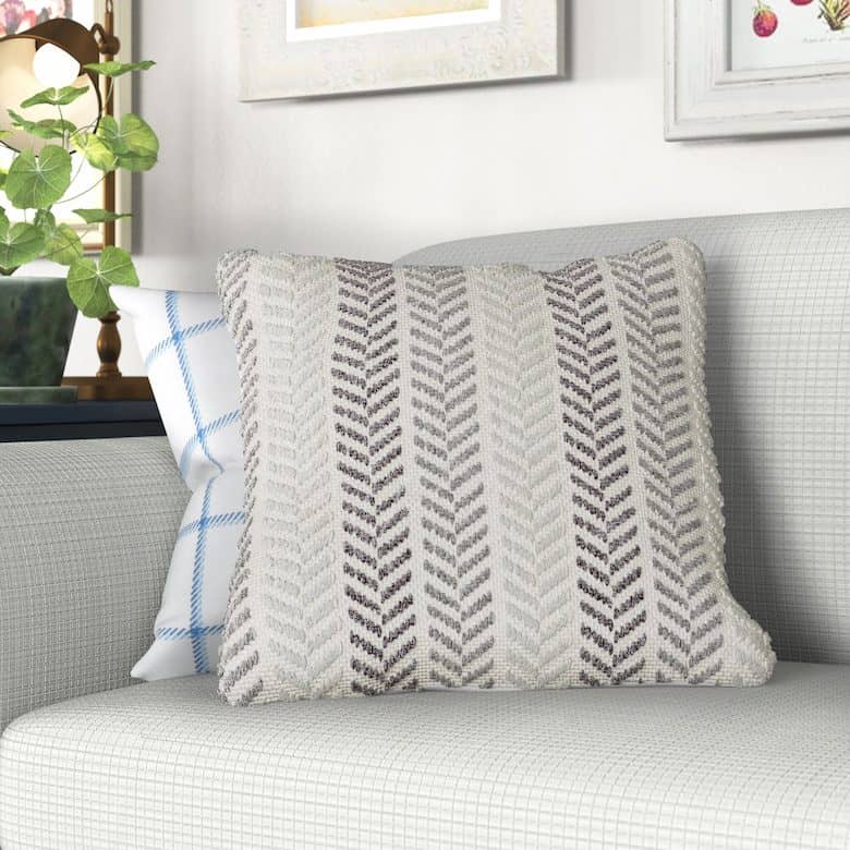 Decorative pillow with a herringbone pattern on a light gray couch