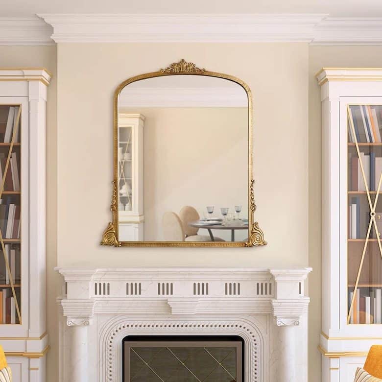 White fireplace with gold mirror and bookcases