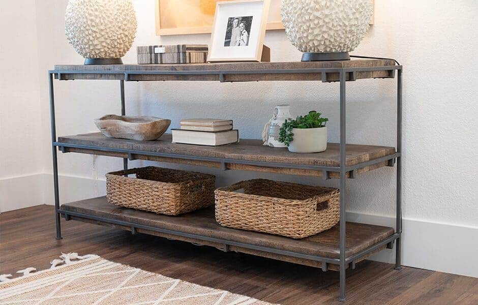 Rustic console table with woven baskets, decorative lamps, and framed photos
