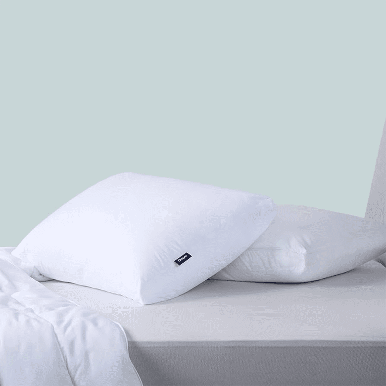 White pillows on a bed with grey sheets