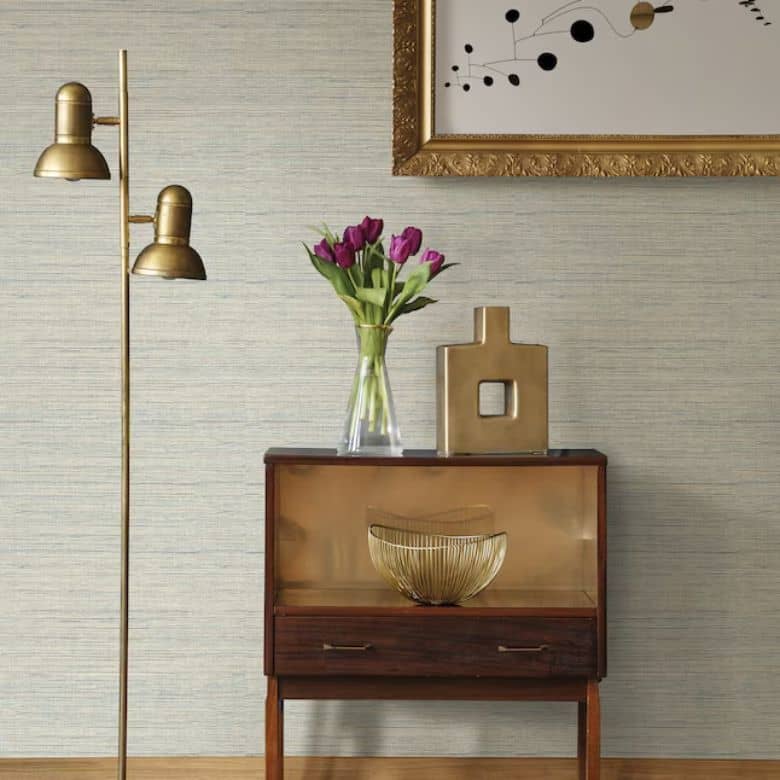 Mid-century modern corner with brass floor lamp, wood cabinet, and purple tulips in a glass vase