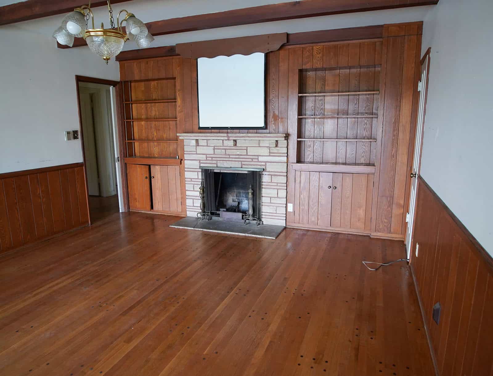old living room with a projector screen and dingy fireplace