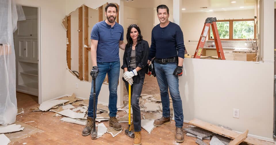 courteney cox celebrity iou episode with drew scott and jonathan scott posing with sledgehammers