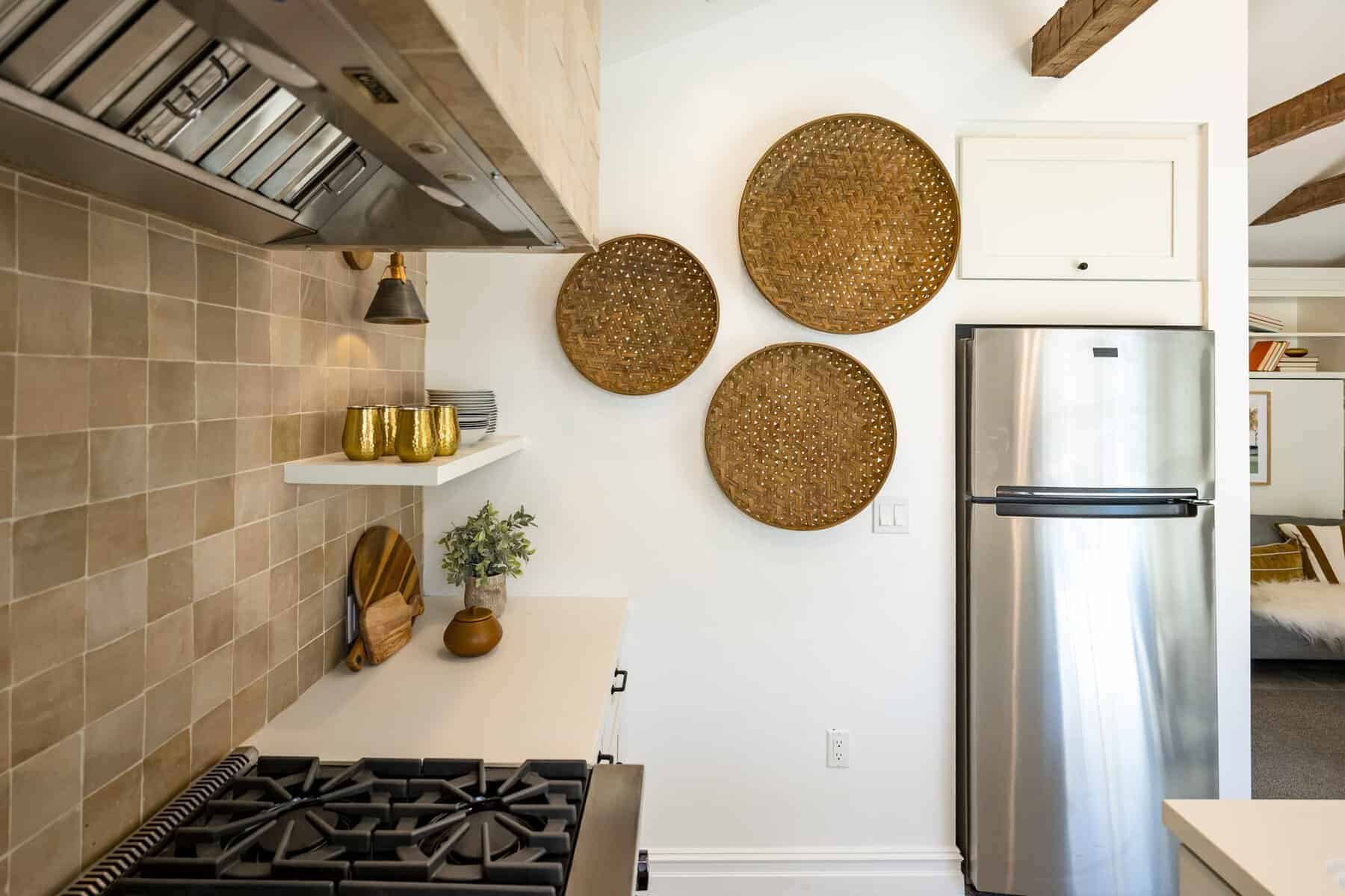 Kitchen with gas stove, stainless fridge, and decorative woven baskets