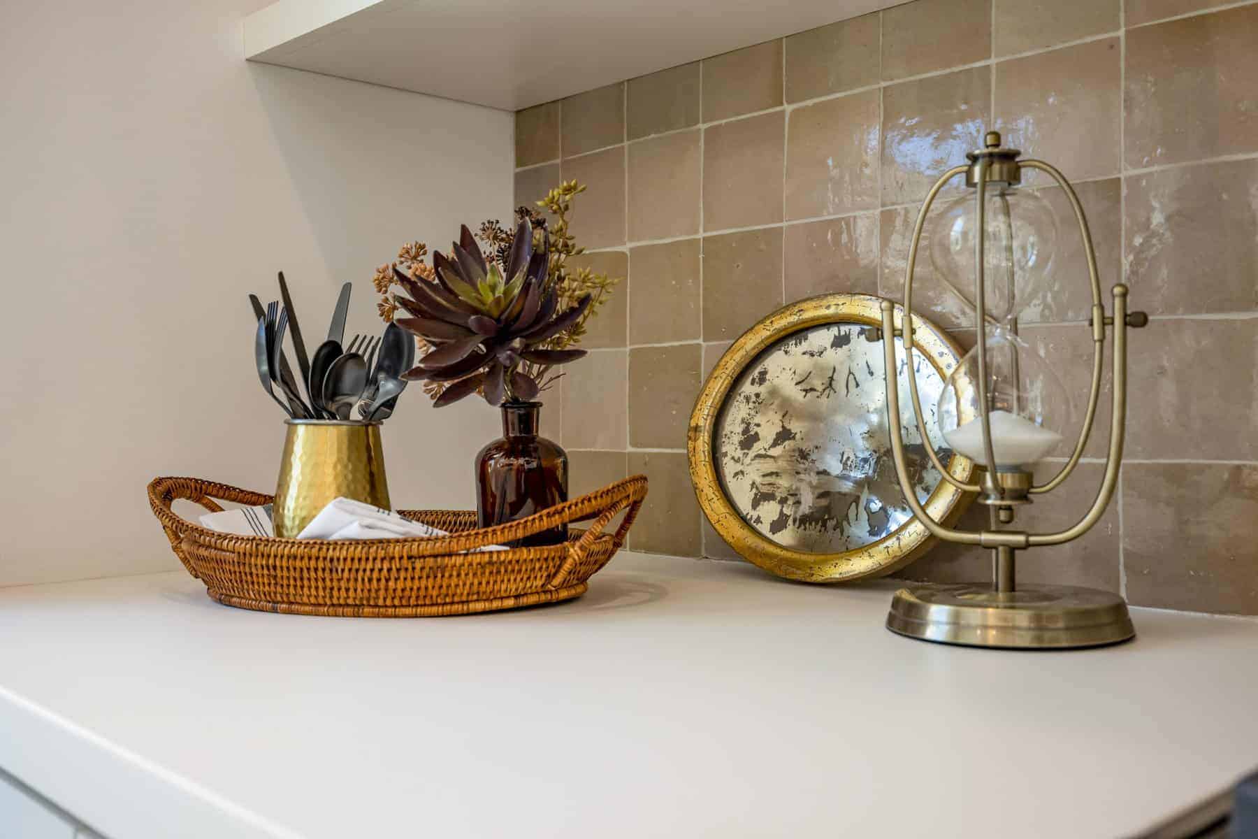 Countertop with a wicker tray, utensils, succulents, and decorative accents
