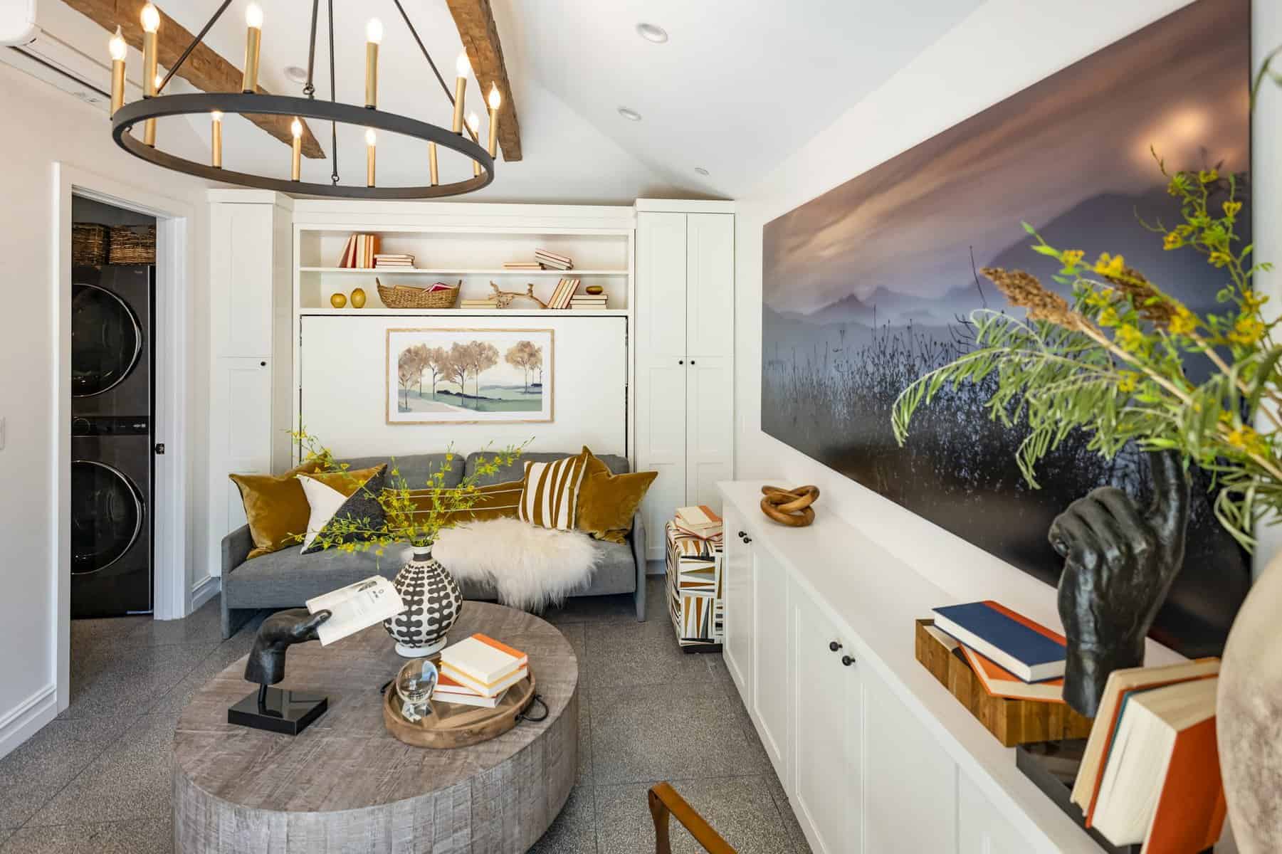 Cozy living room with built-in shelves, modern chandelier, wall art, and decorative accents