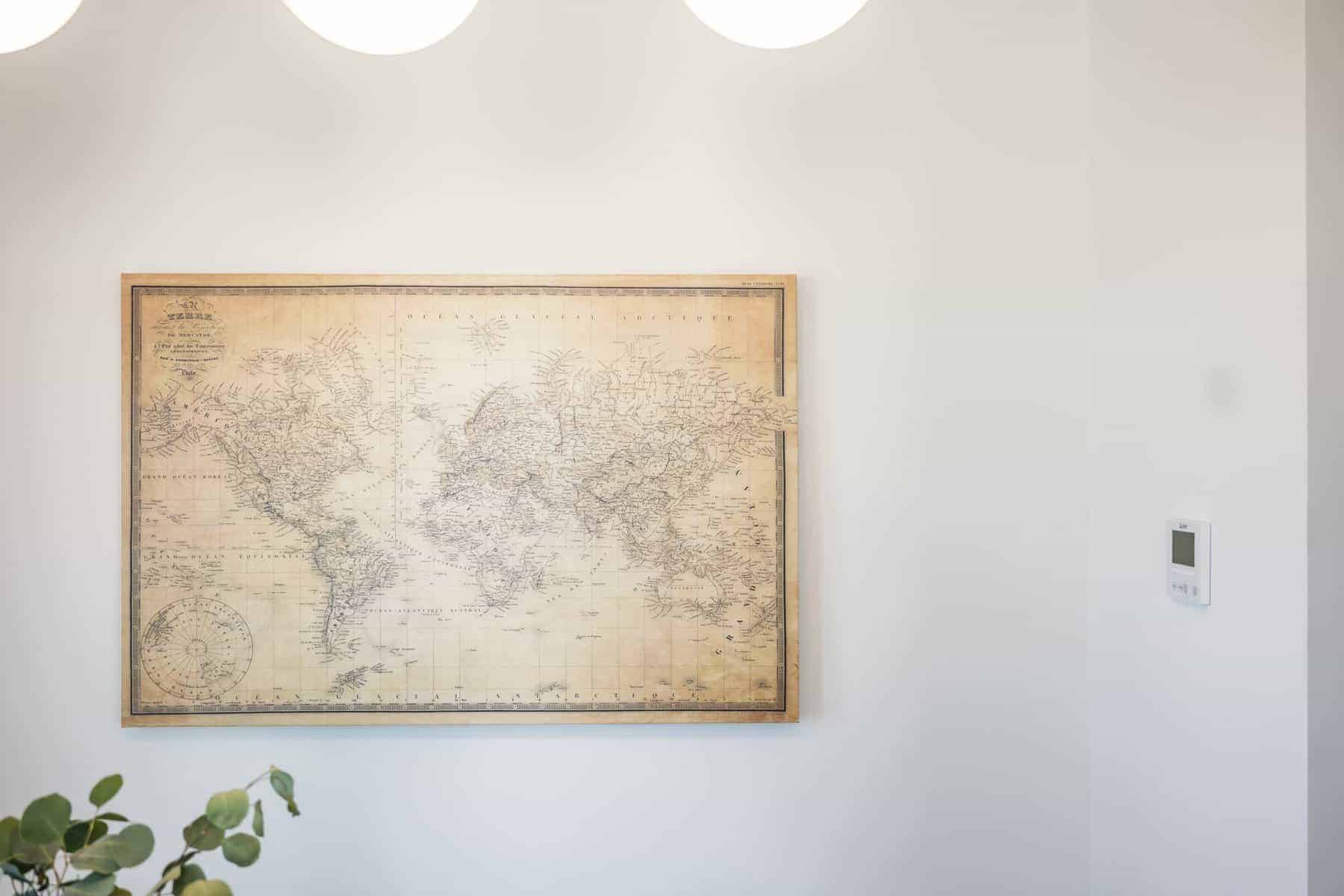 Framed vintage world map hanging on a white wall