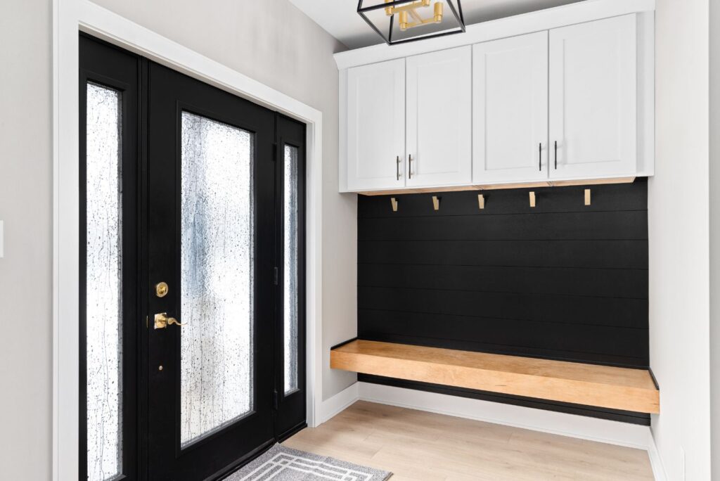 mudroom with built in cabinets, hook wall, and storage bench