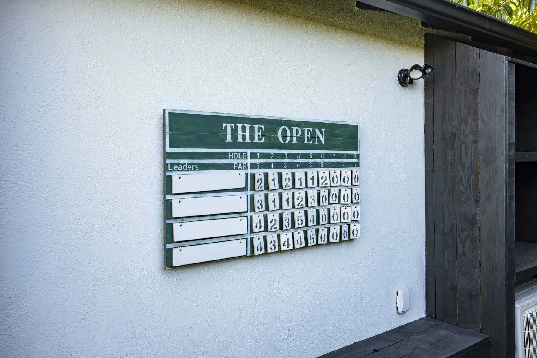 Golf leaderboard scoreboard for "The Open" mounted on exterior wall