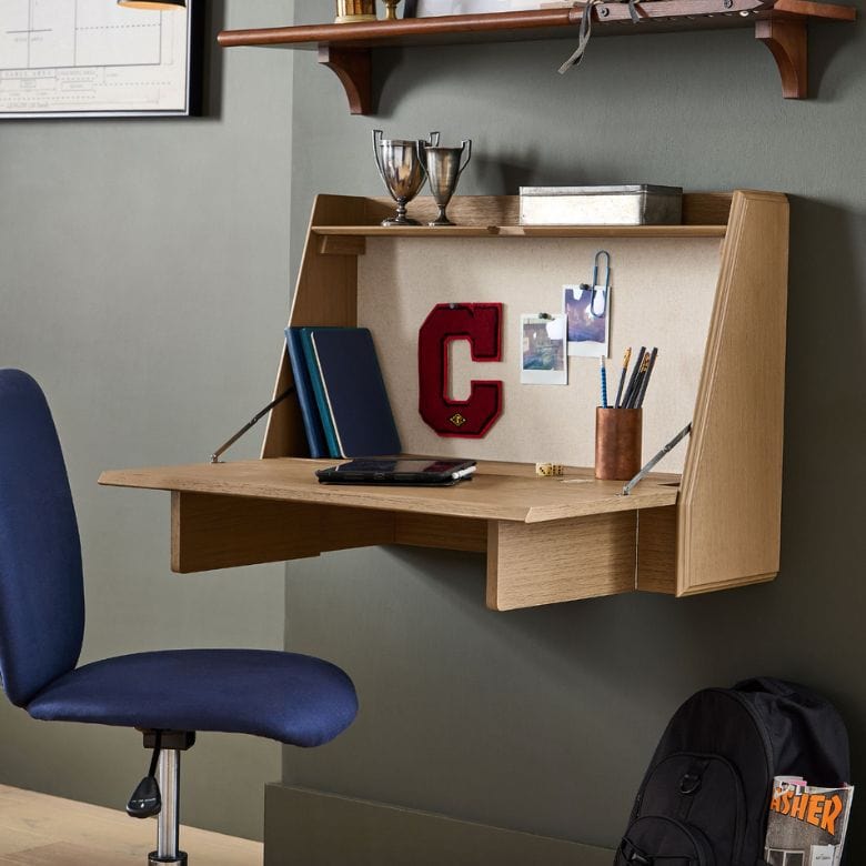 A desk with a shelf and chair in a room.