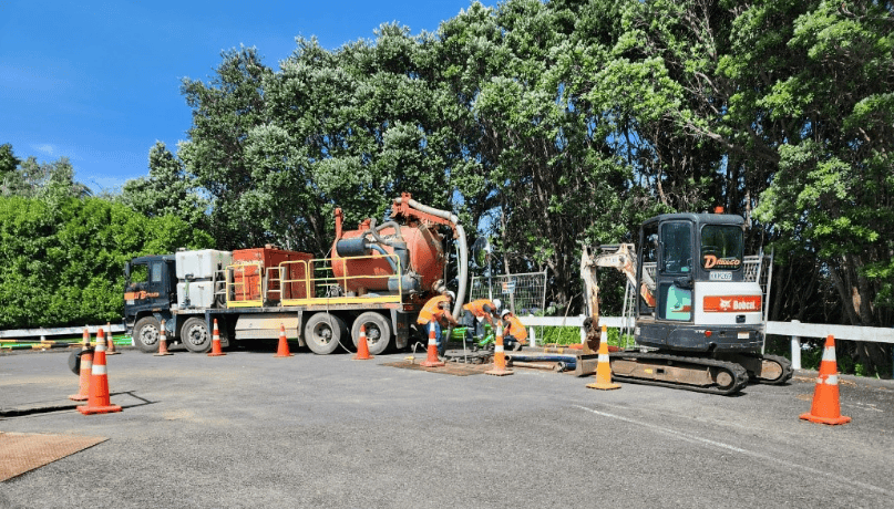 Mobile highway drainage and road repair equipment working on a road construction site in New Zealand.