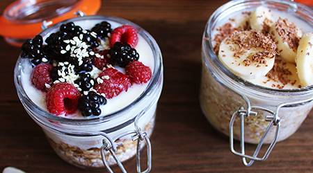 two jars of yogurt with berries and oats and bananas and oats