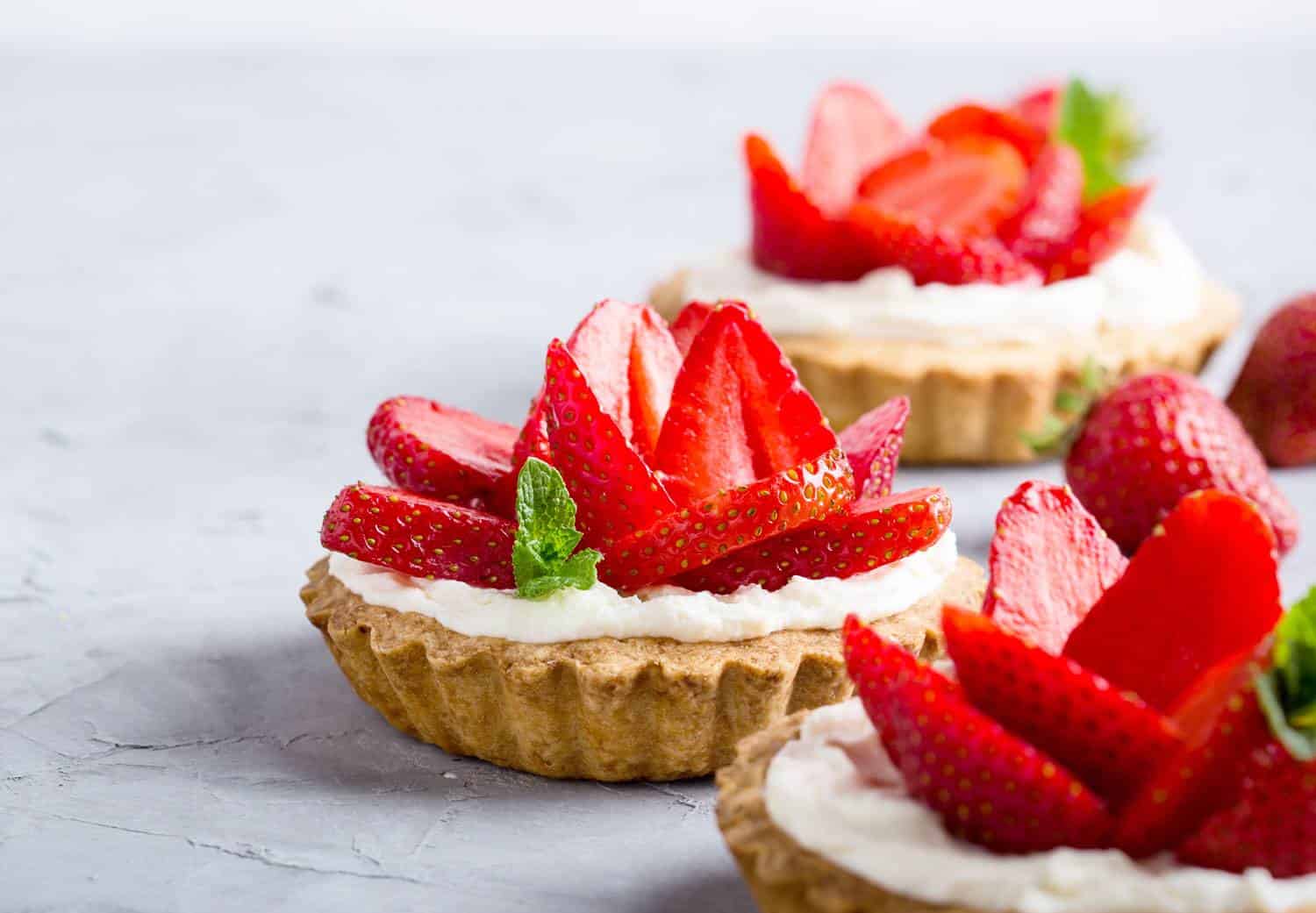 Plant-based Pro Series™ : Strawberry vanilla cream cheese tarts over light gray table