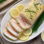 Terrine de poisson saumon cabillaud tranchée sur plat avec citron et ciboulette