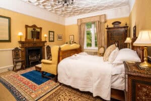 Elegant bedroom at Erchless Castle Estate with antique furnishings and historic decor.