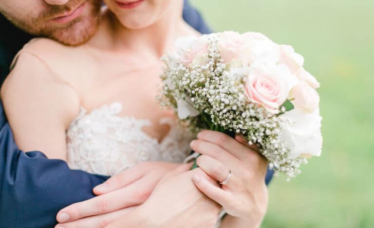 Elegant wedding couple holding pastel pink and white bouquet at Erchless Castle Estate.