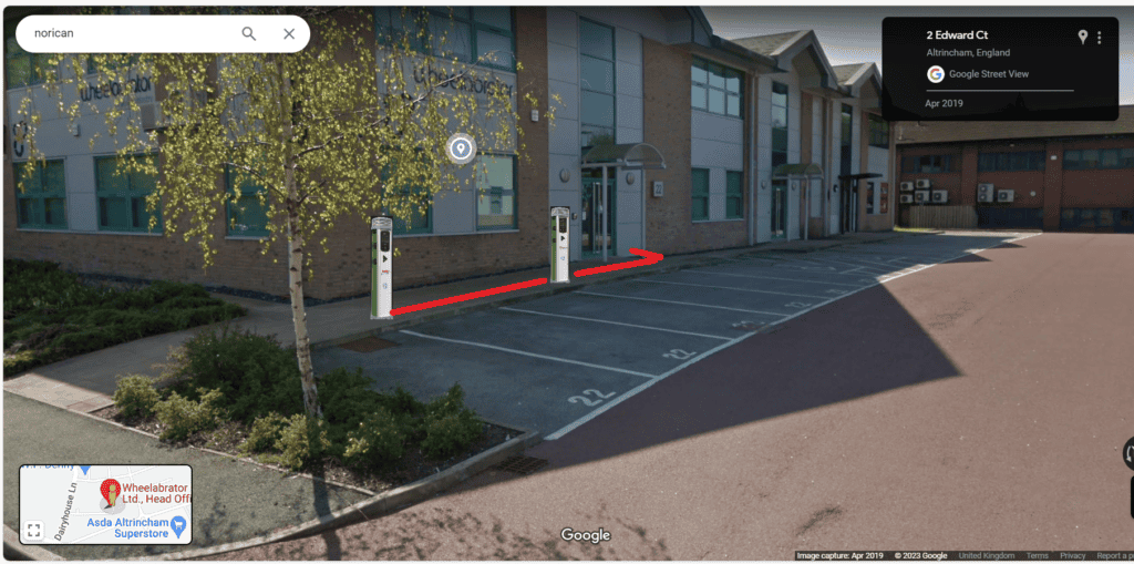 EV charging station with designated parking spaces and bollards for electric vehicle charging.