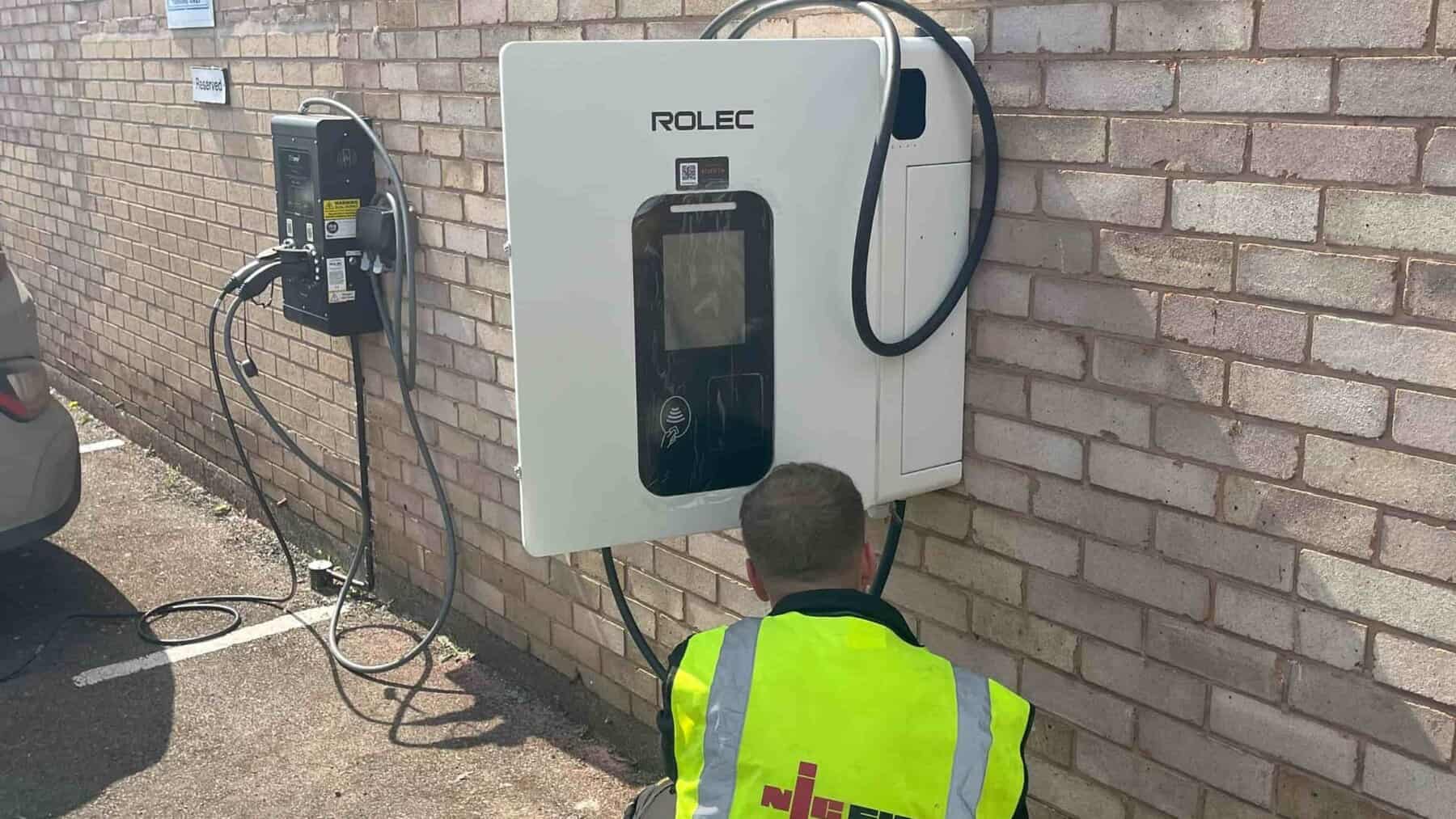Electric vehicle charger mounted on brick wall, ready for maintenance and inspection.