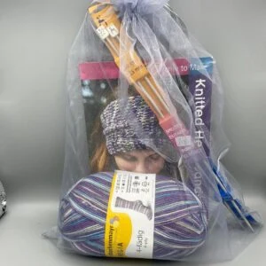 Colourful knitting yarns and knitting needles in gift bag, perfect for knitting projects and DIY crafts, supplied by Fabric & Finery UK.