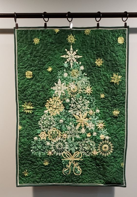 Festive Christmas tree quilt with intricate snowflake and star embroidery, green background, perfect for holiday decoration and Christmas crafts.