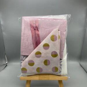 Bright pink fabric with a zipper and coordinating printed textiles, ideal for sewing, dressmaking, and quilting projects, crafted from high-quality materials for custom fashion and home décor.